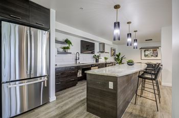 A modern kitchen with a marble countertop and stainless steel appliances.